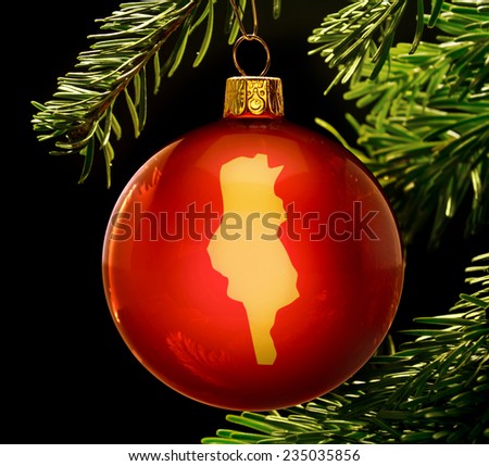 A red bauble with the golden shape of  Tunisia hanging on a christmas tree isolated on black.(series)
