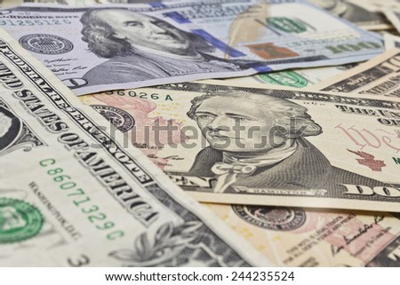 Close Up shot of several dollar bills laying chaotically around.President Hamilton in focus.