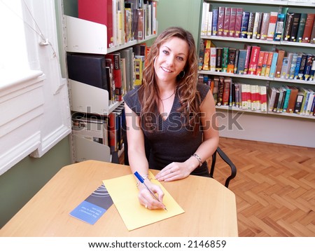 Girl taking notes in the library at work