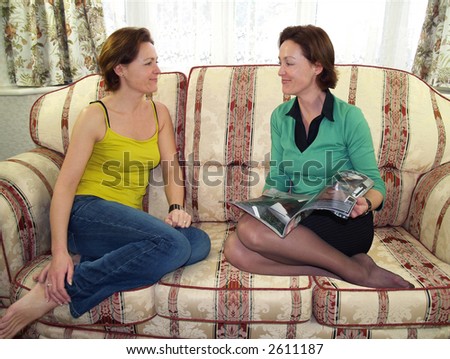 Photoshop Twins sat on the sofa discussing a magazine