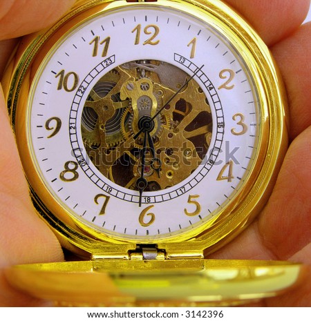 Hand held gold pocket watch checking the time.