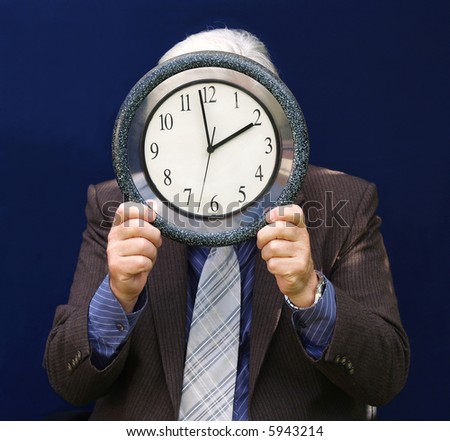 Senior executive holding a clock with end of Lunch Time