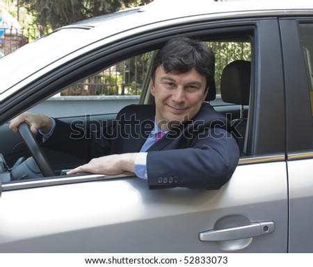 A smiling and satisfied customer with his brand new car