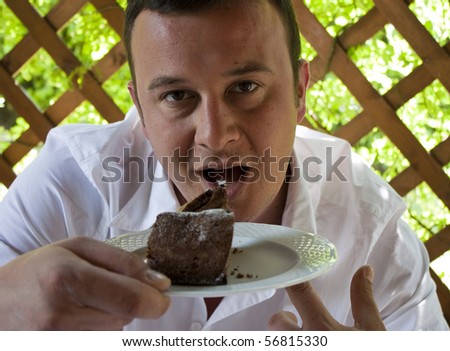 Portrait of a Greedy Young Man with a big Slice of Chocolate Cake