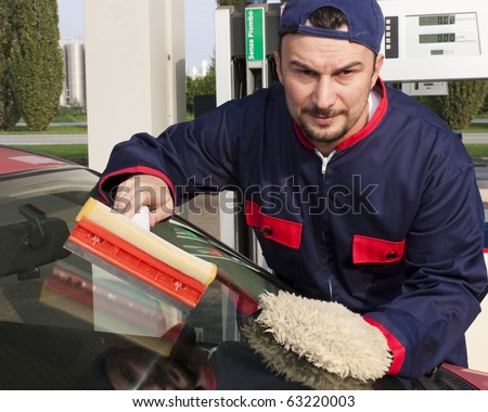 Gas Station Worker Cleaning Windshield at Service Station