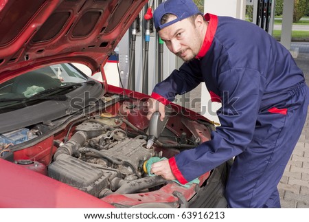Mechanic Checking Oil Level at Gas Station