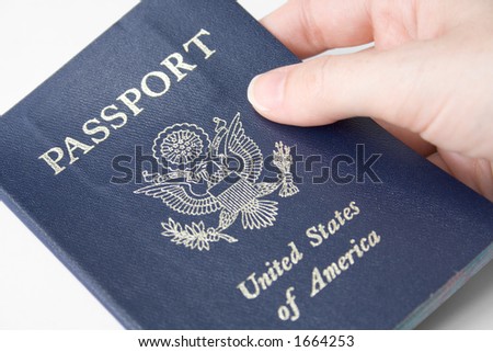 Closeup of an American passport held by a female hand, with selective focus on the word \