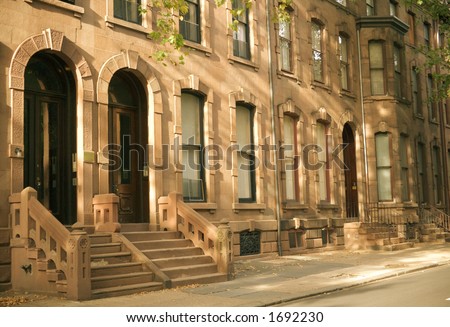 Brownstone row houses on a residential street.