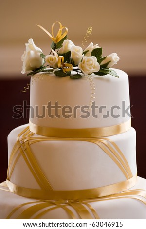 stock photo Top of Wedding Cake Decorated with Roses and Gold Ribbon