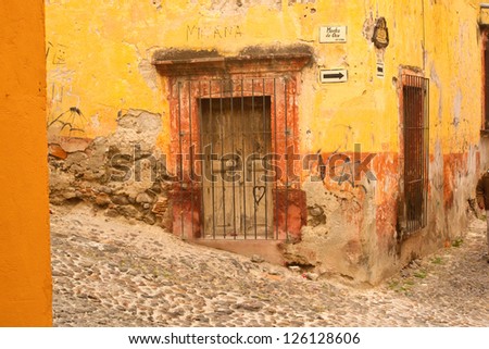 Weathered building facade on a hillside street in old Mexico