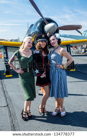 BULLHEAD CITY, ARIZONA - APRIL 6: Gals from the Pinup Patriettes pose in period fashion with vintage World War II warplanes at an air show in Bullhead City, Arizona on April 6, 2013.