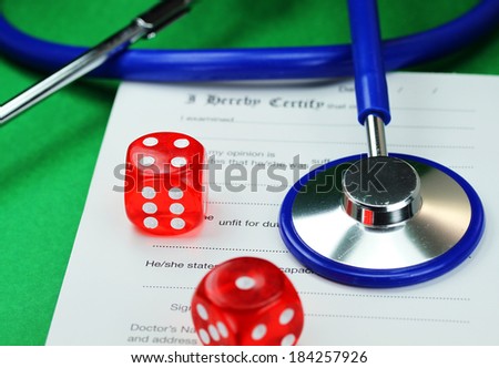 A Doctors desk with two dice placed next to a blue stethoscope all placed on a doctors sick certificate pad, asking the question, do you gamble with your health