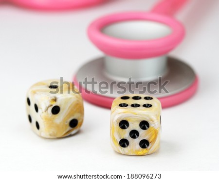 A Doctors Pink stethoscope with two white marbled dice with black spots dice placed next to it, asking the question, do you gamble with your health.