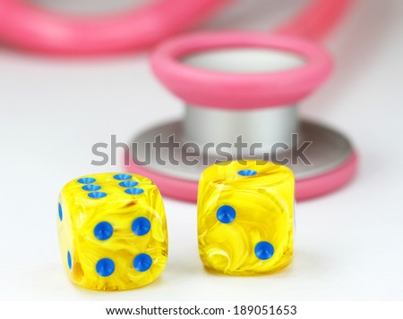 A Doctors Pink stethoscope with two yellow dice with light blue spots dice placed next to it, asking the question, do you gamble with your health.