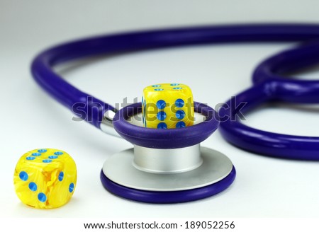 A Doctors purple stethoscope with two ivory marbled dice with black spots placed next to it, asking the question, do you gamble with your health.