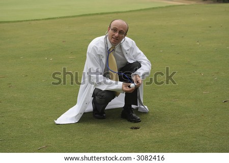 Medical doctor on the golf course checking a golf ball with his stethoscope, in the hope of helping you improve your game