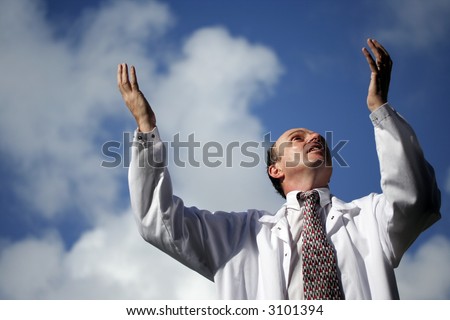 Doctor with his arms raised to the blue sky wearing his white laboratory coat