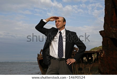 A businessman in the middle of a rusting ship looking out for a bright business future with his hand near his head shielding the sun