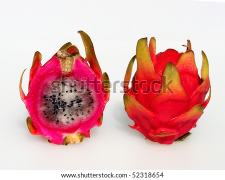 Two Fresh ripe round colorful dragon fruit on a white background, one of which has been cut in half to reveal the succulent white flesh.