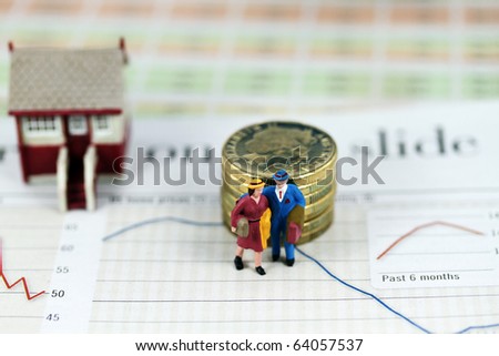 A couple with suitcases walking away from their house & mortgage signified by a pile of gold coins representing debt, after a bank has repossessed their house.