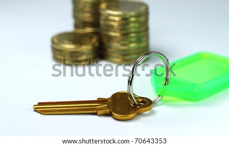 A golden key in the front of three piles of gold coins, asking the question how are you going to unlock your financial Goals?