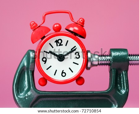 A red alarm clock placed in a Grey clamp against a pastel pink background, asking the question do you manage your time effectively?