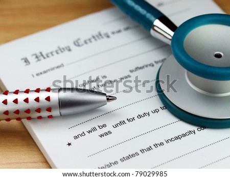 A doctor’s desk showing a teal stethoscope, doctors pen and sick certificate pad.