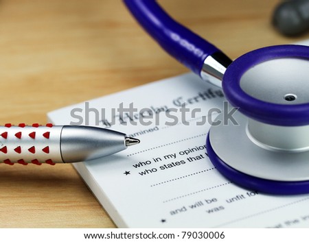 A doctor’s desk showing a purple stethoscope, doctors pen and sick certificate pad.
