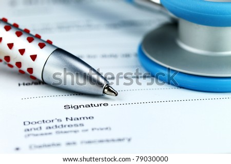 A doctor’s desk showing a light blue stethoscope, doctors pen and sick certificate pad.