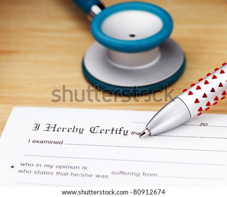 A doctor’s desk showing a teal colored stethoscope placed on a sick certificate pad.