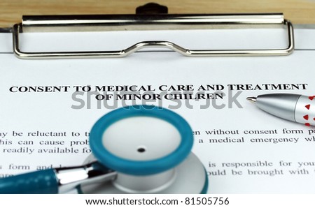 A Teal colored stethoscope on a metal  clipboard along with a pen  for you to sign a medical consent form for a minor.