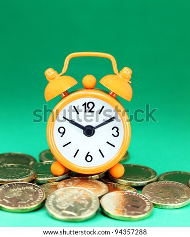 An organe alarm clock placed on some golden coins with a pastel green ground, asking the question how long before your investment matures?