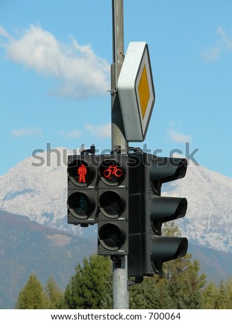 red pedestrian traffic light with mountains in background