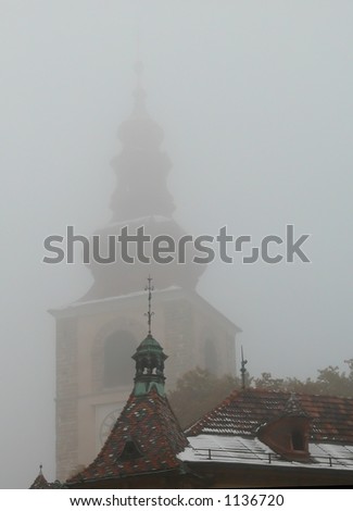 small church tower with a big church tower in the background seen through the fog, Ptuj, Slovenia, Europe
