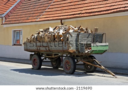 tractor-drawn trailer full with chunks of wood