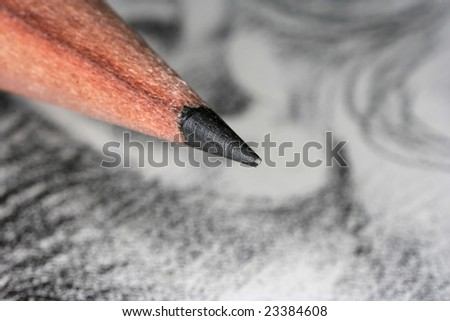 macro shot of a drawing pencil and part of the drawing in the background