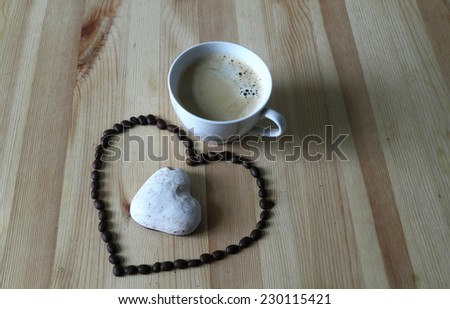 Cup of coffee and coffee grains in the form of heart