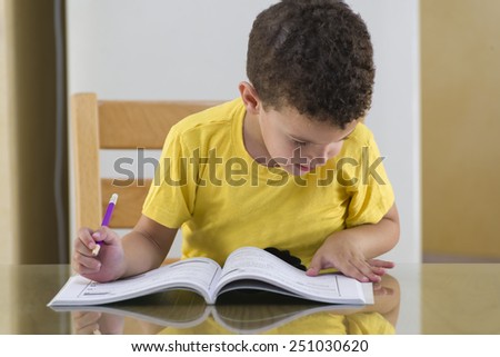 Young Schoolboy Studying Hard Doing His Homework