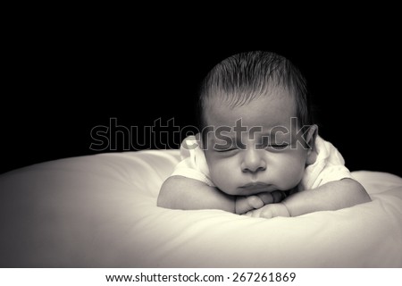 Newborn Baby Boy Sleeping in His Bed Over Black