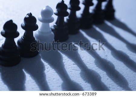 Dare to be different - A single white pawn among black pawns.