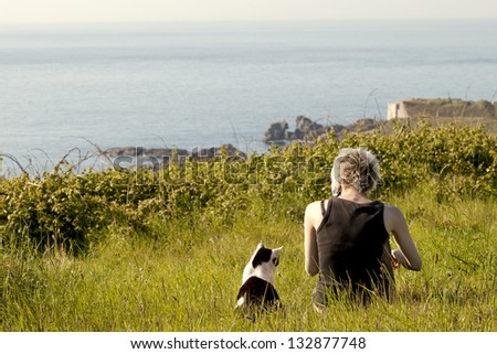 girl with her cat looking at sea