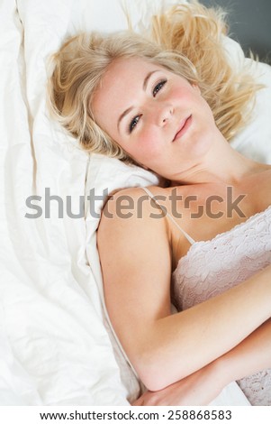 Young woman laying on a white comforter