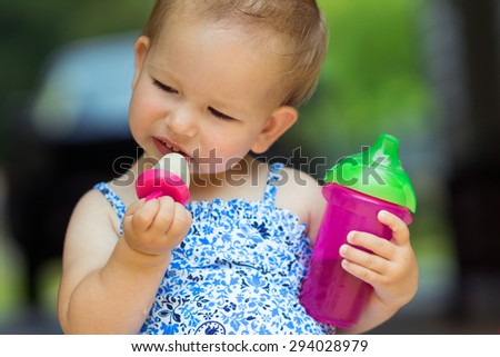 Toddler with homemade frozen treat and juice