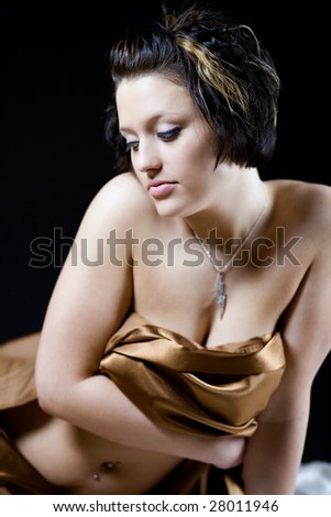 Model looking down with satin sheet covering her
