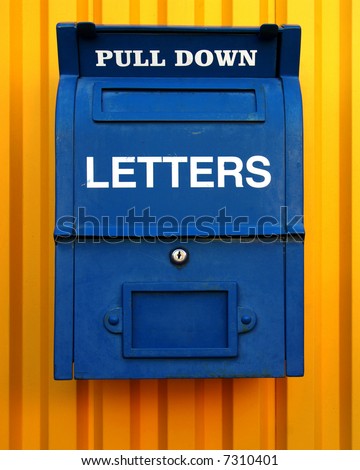 Old blue letter box on yellow wall