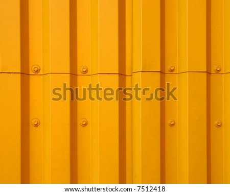 Yellow painted metal siding with attaching screws