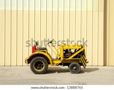 Yellow airplane tow truck at an airport