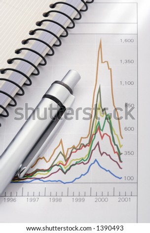 pen and notebook on graph (focus on the pen)