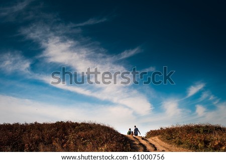 A family of a man, woman and son walking.