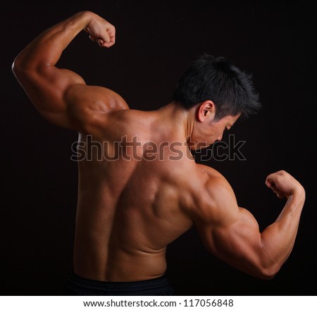 Body Builder posing with his back muscles on black background